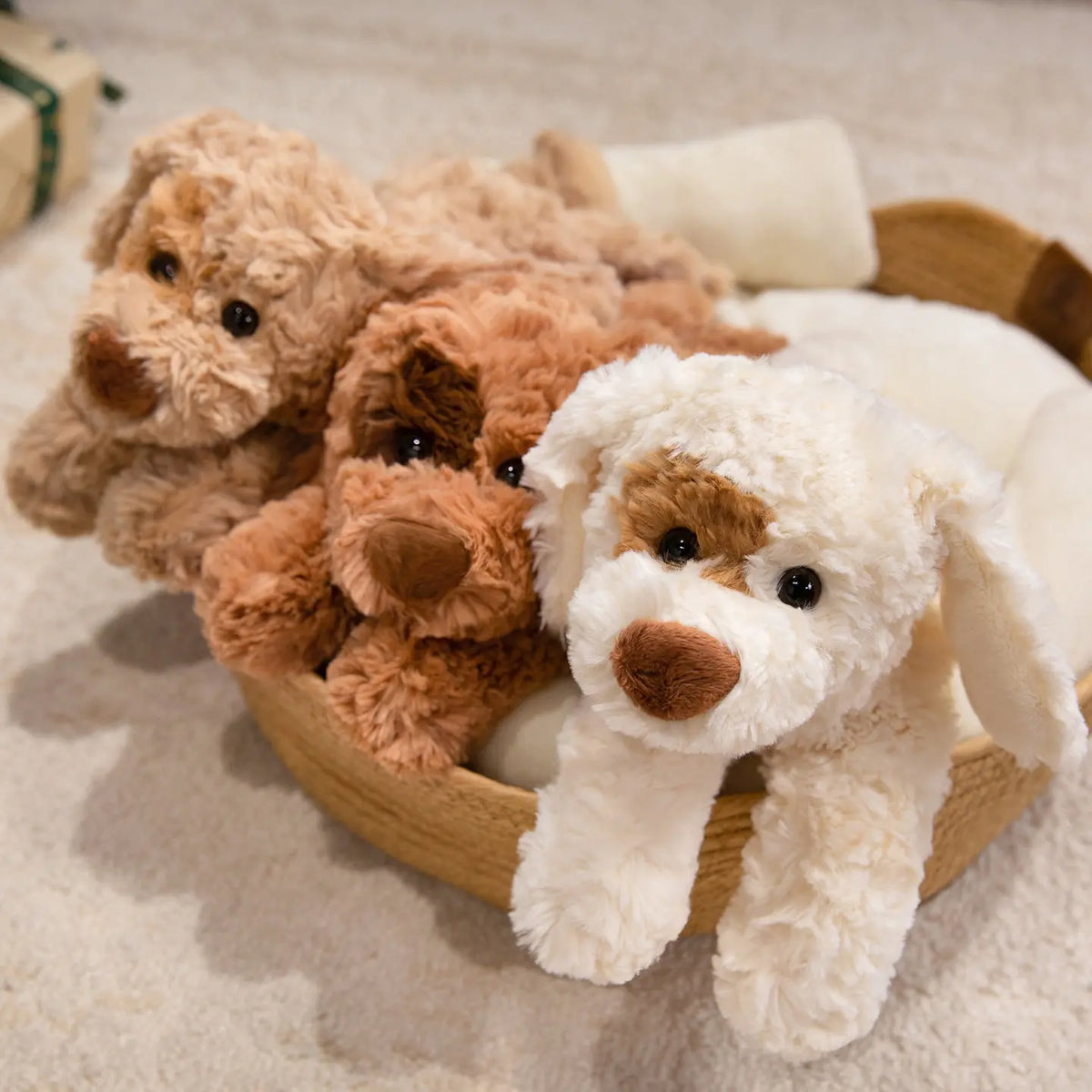 Un cuenco de madera lleno de tres peluches de perros de oso esponjosos en tonos marrón y crema.