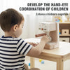 A young boy is using a kids pretend play coffee machine set to develop hand-eye coordination.