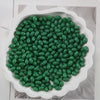 A pile of green oval glass rice grain beads for jewelry making