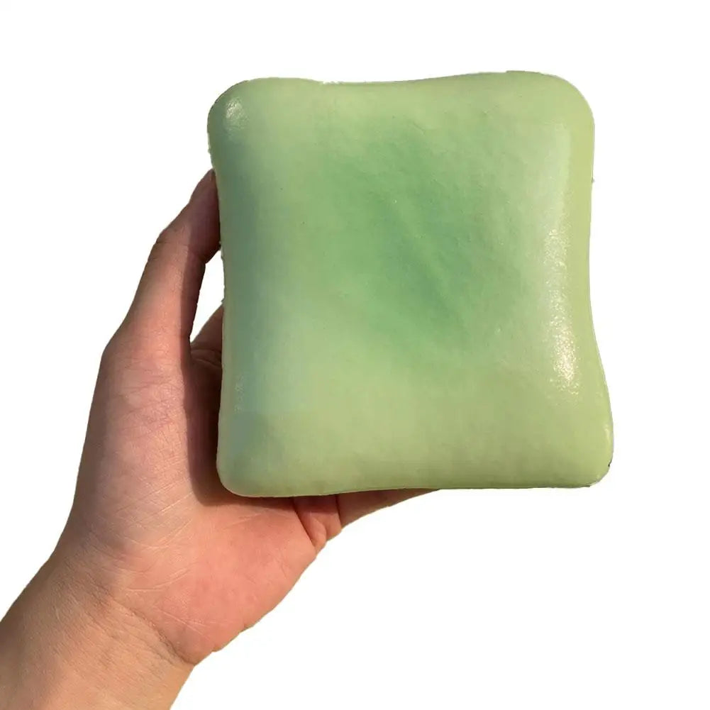 A hand holds a light green squishy toast stress relief toy.