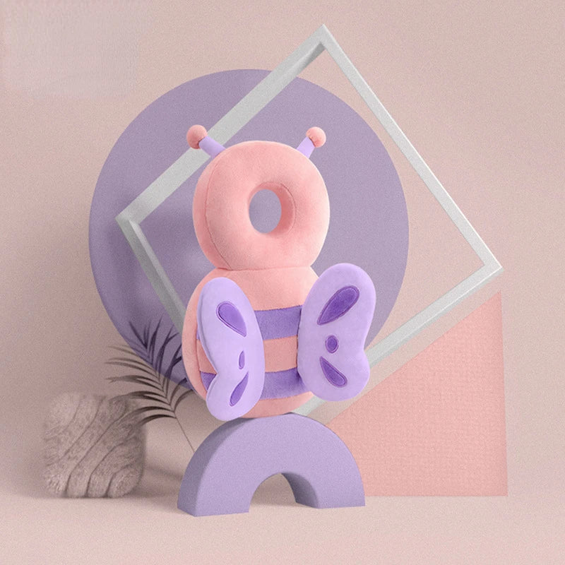 A soft pink and purple stuffed bee shaped pillow backpack for newborns is displayed against a light background.