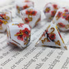 A set of milk white resin dice featuring a black kitten design, arranged on a piece of paper.