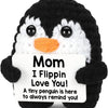 Black and white penguin plush toy with a sign that reads Mom I Flippin Love You