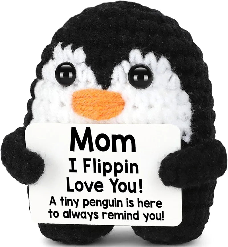 Black and white penguin plush toy with a sign that reads Mom I Flippin Love You