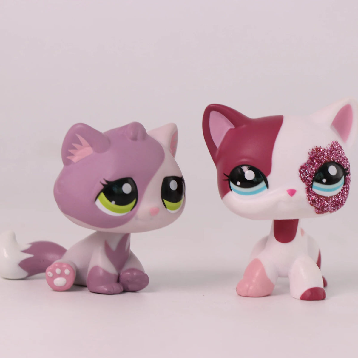 A pink and white Shorthair Cat Bobble Head figurine with large eyes and pink accents.