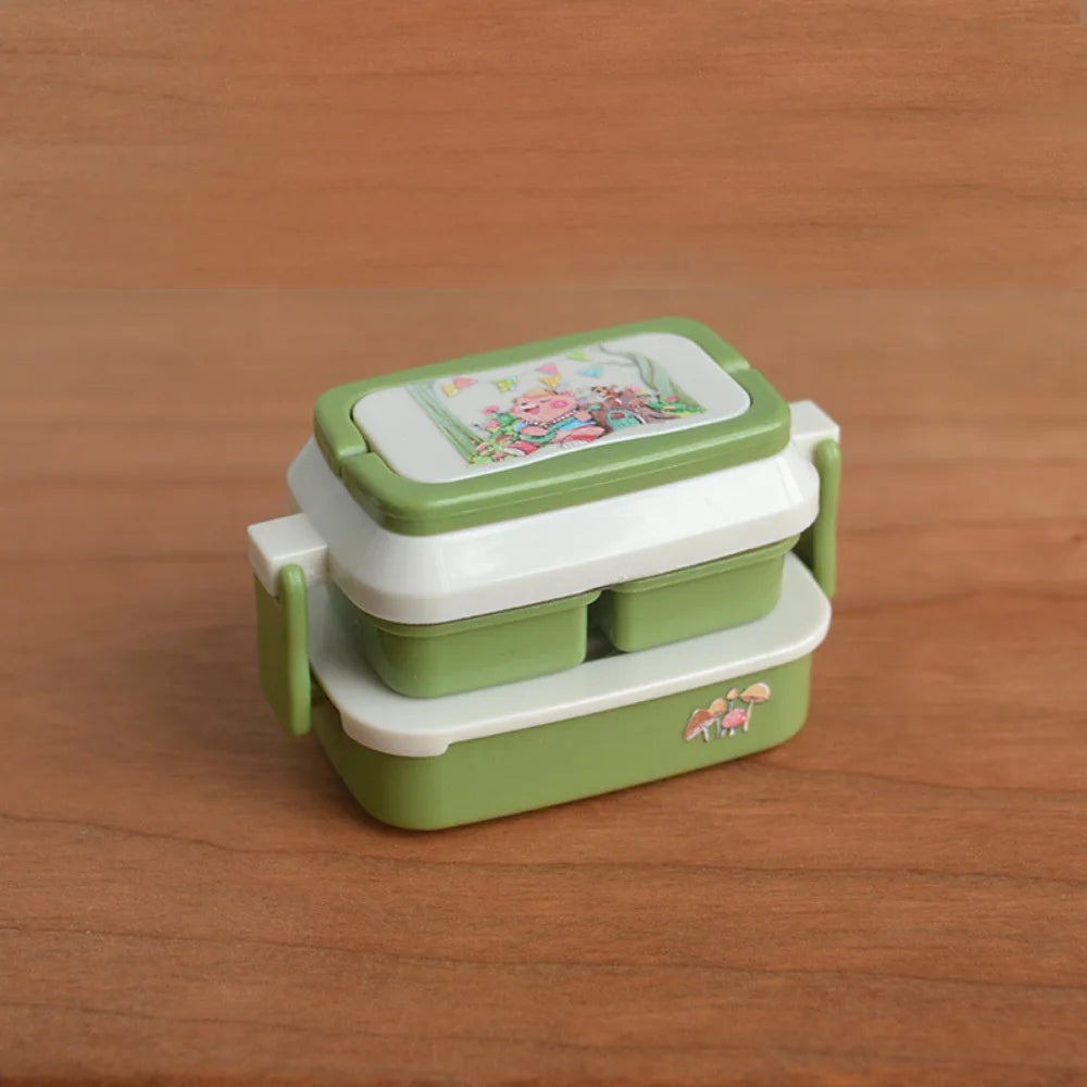 A miniature doll picnic lunch box with a handle in green and white is shown on a wooden surface.