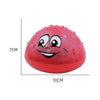 A bright red, spherical bath toy shaped like a smiling face with black eyes and mouth.