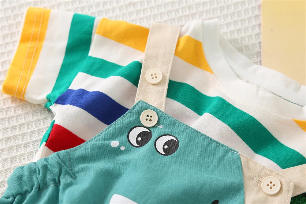 A close-up of a kids striped dinosaur two-piece outfit set featuring white, yellow, green, and blue stripes.