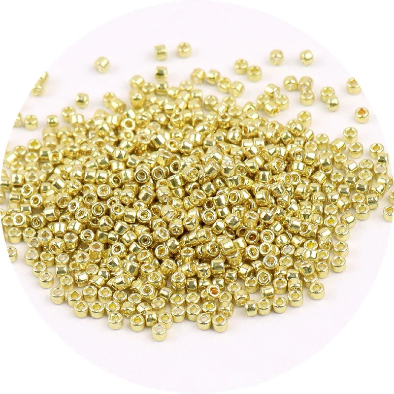 A pile of small, gold-colored metallic glass beads for jewelry making.