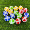 A set of colorful sticky balls in yellow, green, and red are arranged on green grass for a target shooting game.
