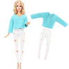A fashion doll outfit set featuring a light blue fuzzy sweater and white pants with cutouts.
