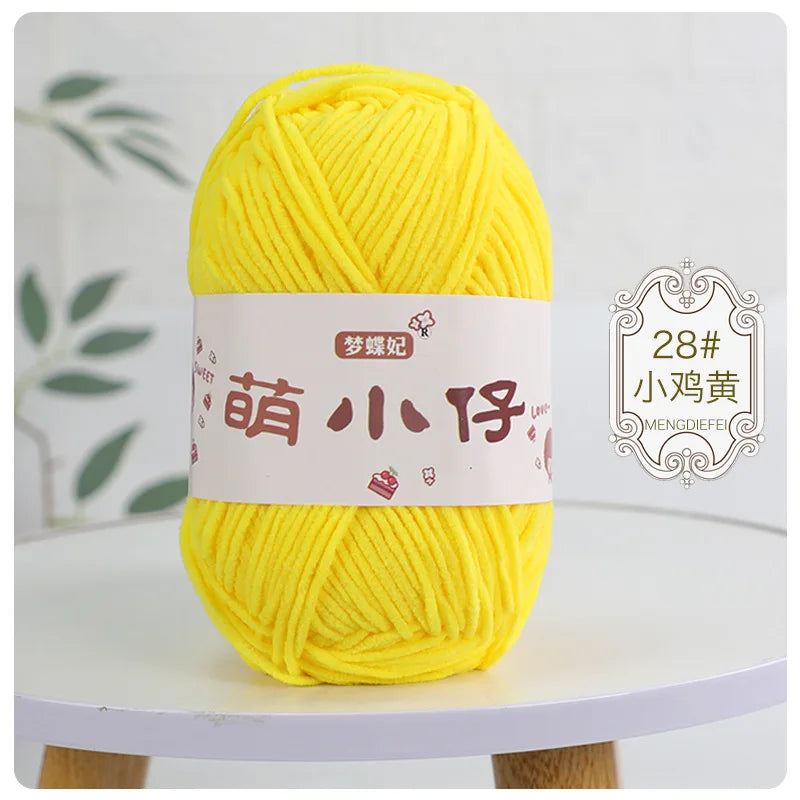 A ball of bright yellow chenille yarn labeled with Chinese characters for knitting and crochet.