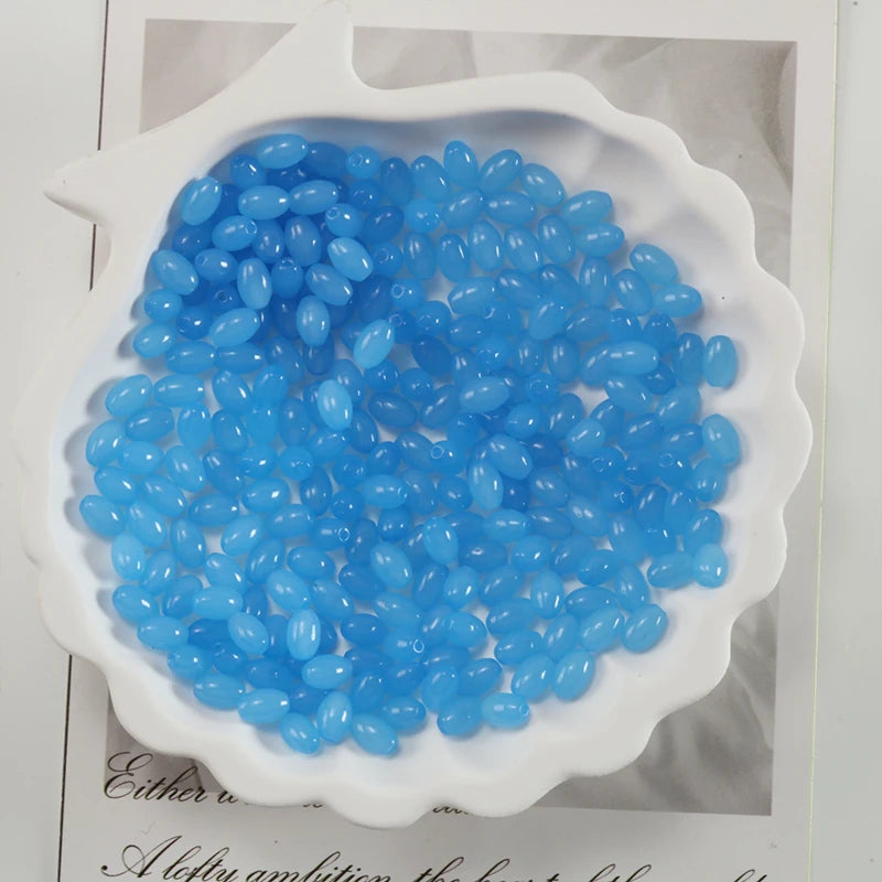 A pile of oval blue glass rice grain beads for jewelry making