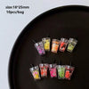 A collection of colorful DIY sunflower charms in various sizes displayed on a black plate.