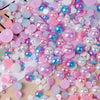 A close-up of mixed resin rhinestone pearls in various shades of pink, blue, and iridescent colors.