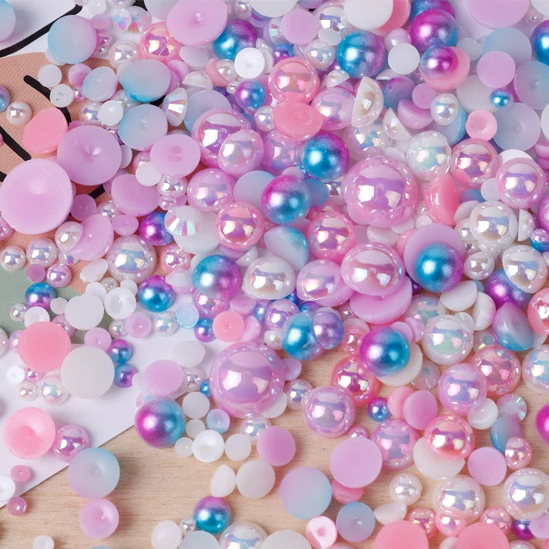 A close-up of mixed resin rhinestone pearls in various shades of pink, blue, and iridescent colors.