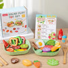 A wooden salad pretend play food set with various colorful vegetables and fruits arranged in a green bowl.