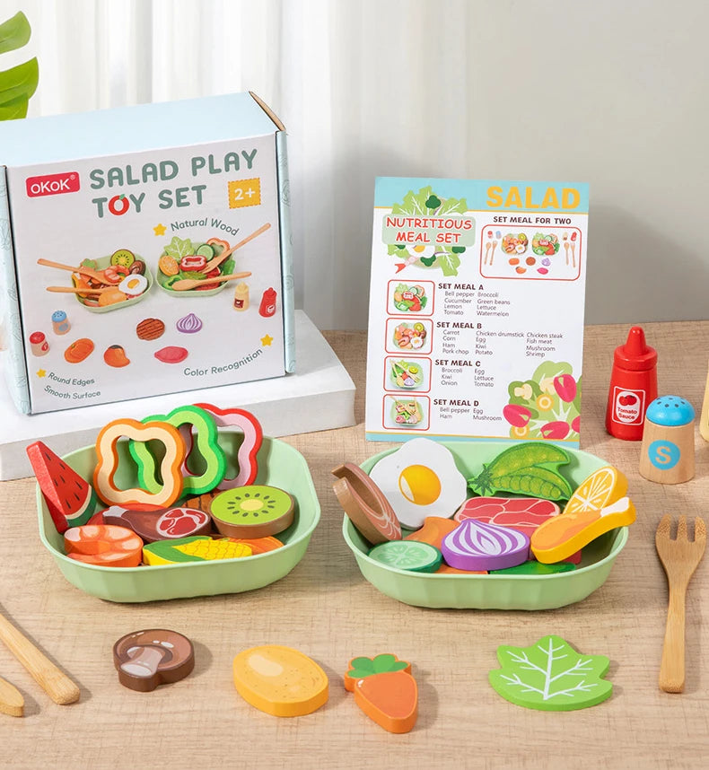 A wooden salad pretend play food set with various colorful vegetables and fruits arranged in a green bowl.