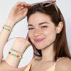 A woman models acrylic star and heart spacer beads on her wrist and ear, showing jewelry making supplies.