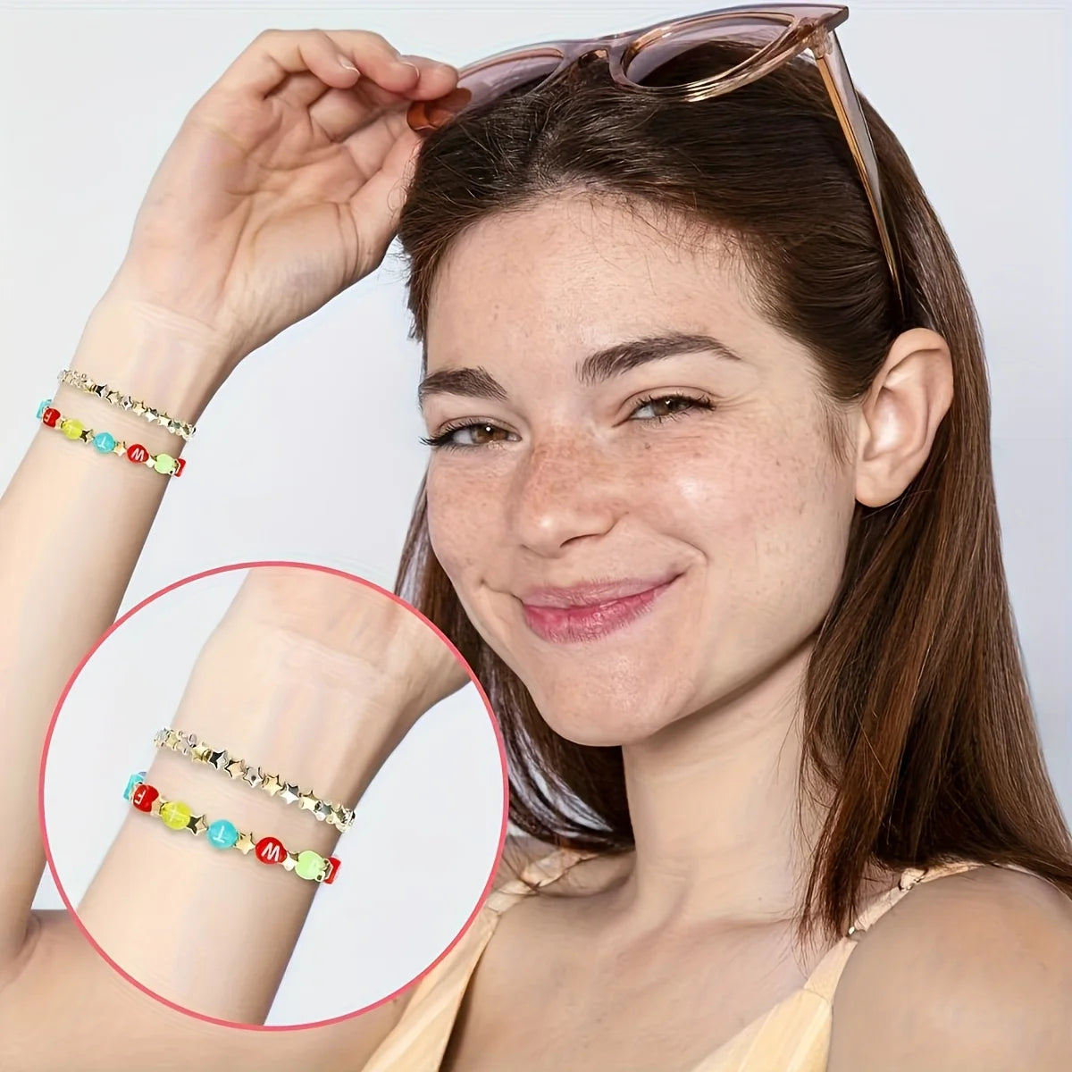 A woman models acrylic star and heart spacer beads on her wrist and ear, showing jewelry making supplies.