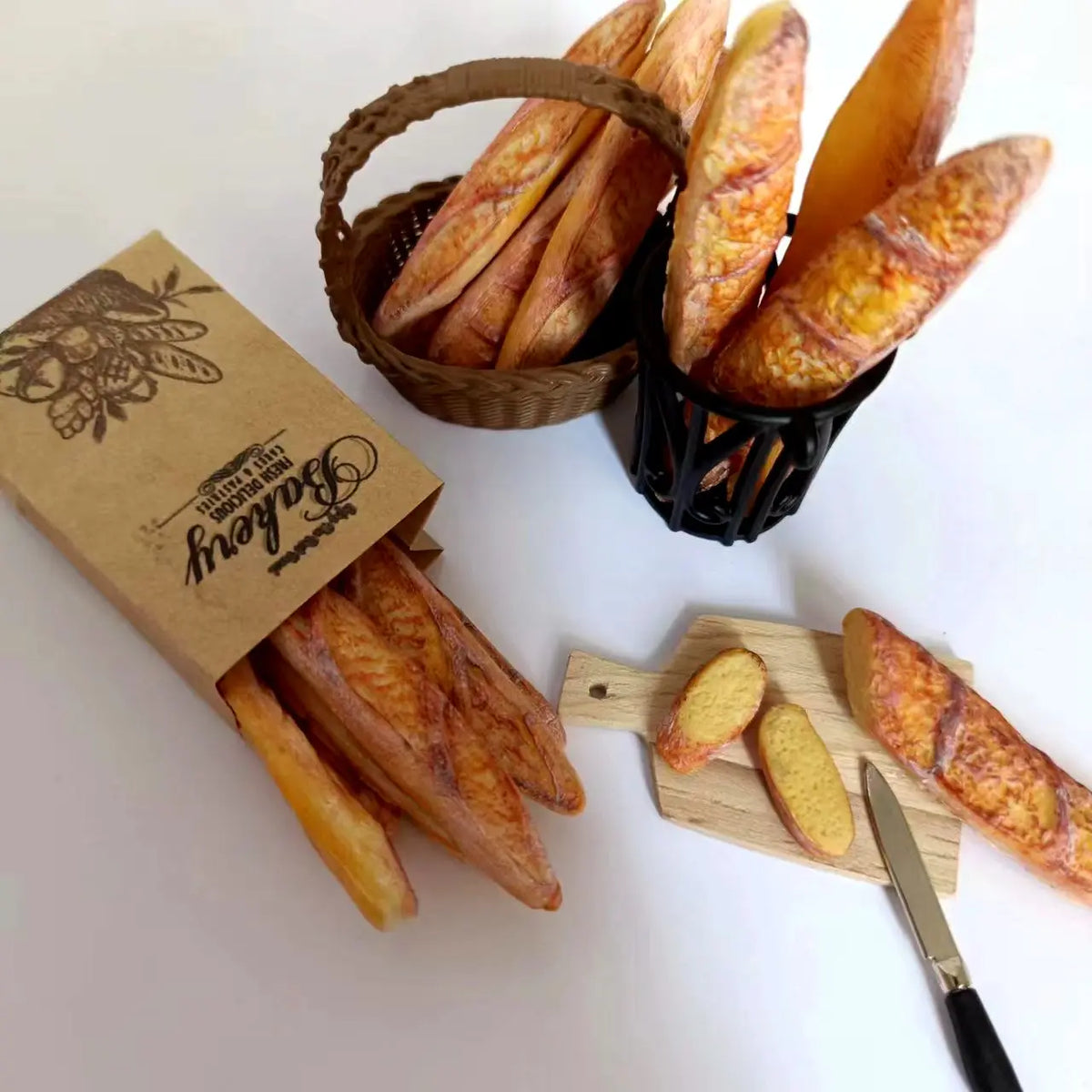 A collection of handmade miniature baguettes in various shades and textures displayed in wicker baskets and on a wooden board