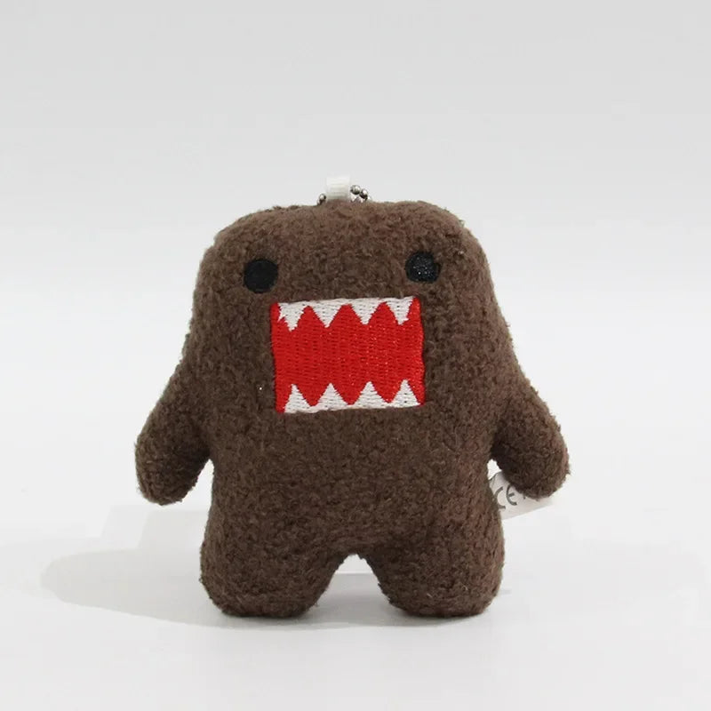 A dark brown, fuzzy plush charm shaped like a monster with a wide open mouth showing sharp teeth.