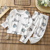 White long sleeve cotton pajama set for kids featuring a pattern of airplanes and hot air balloons.