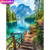A scenic view of a mountain lake with lush green forests and rocky terrain.