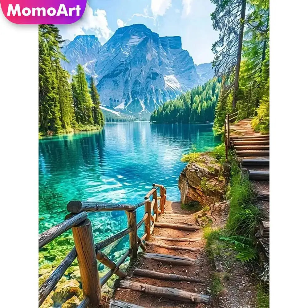 A scenic view of a mountain lake with lush green forests and rocky terrain.