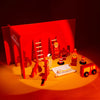 A red wooden building tool set for pretend play featuring ladders, figures, and construction elements on an orange surface.