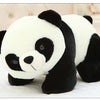 A white and black panda plush pillow with a soft texture is shown in a close-up view.