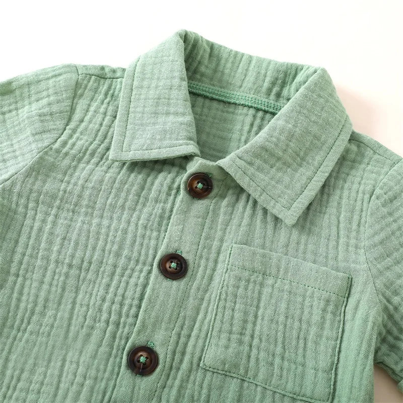 A light sage green baby boy cotton linen shirt with a collar and pocket.