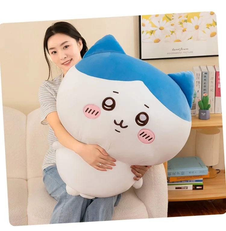 A white and blue Chiikawa plush doll featuring two characters, Hachiware and Usagi, sitting on a light-colored sofa.