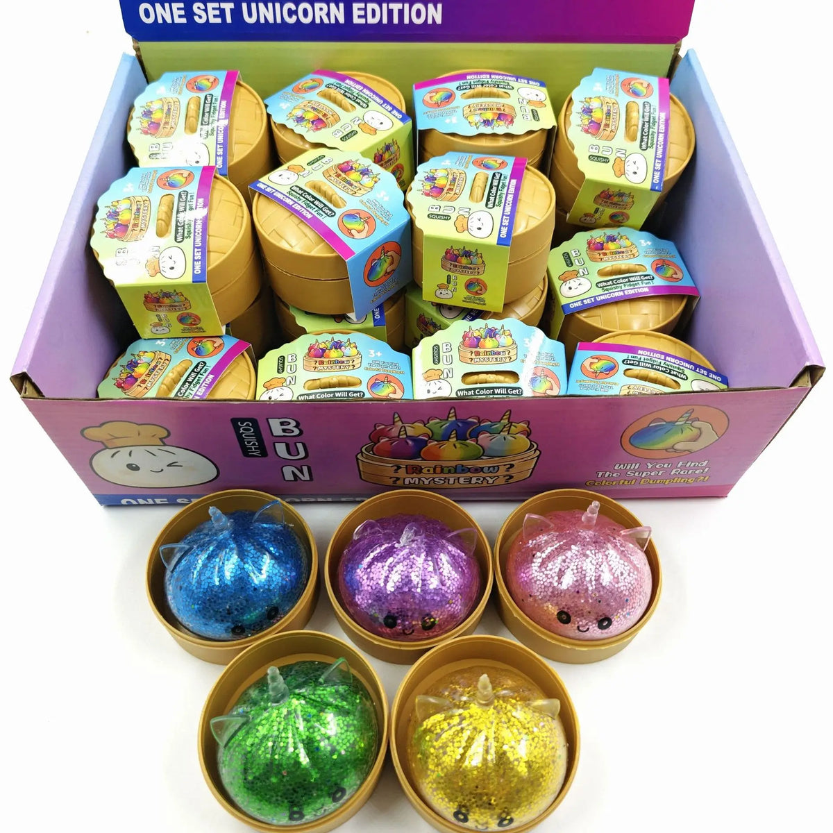 A box of glitter unicorn dumpling squishies in various colors and a set of gold glitter balls.