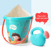 A turquoise bucket and shovel set for kids with sand and water play, featuring a large pile of sand.