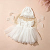 A white lace tulle dress for a newborn baby girl with a matching bonnet, displayed on a light pink background.