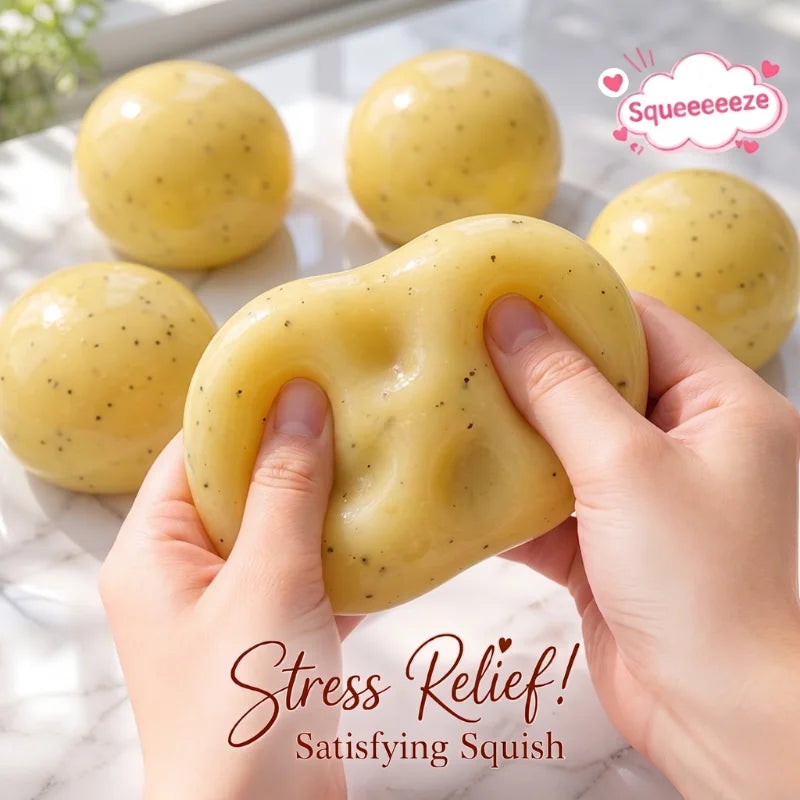 Hands squeeze a yellow mashed potato squish toy stress reliever with several other toys in the background.