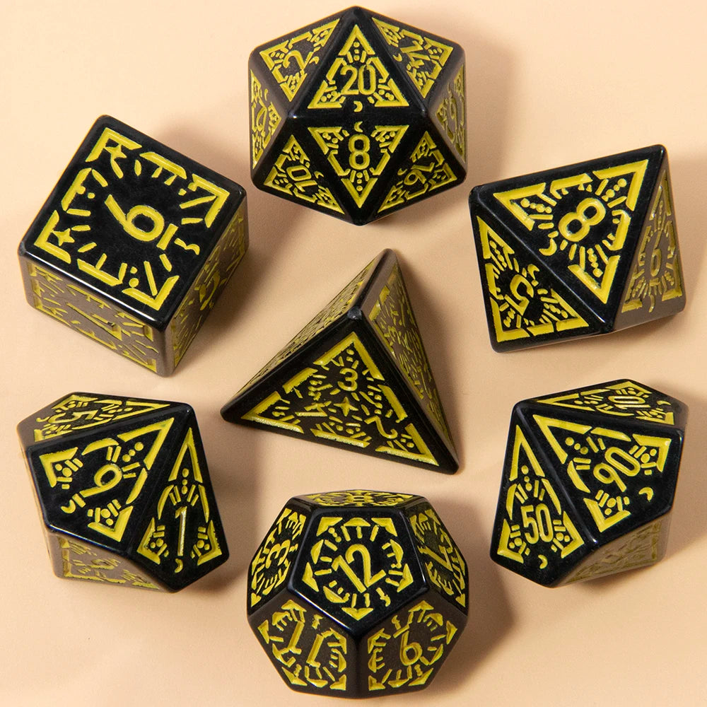 A set of seven fantasy carved polyhedral dice in black and yellow on a beige surface.
