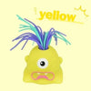 A yellow, screaming monster stress relief toy with purple hair and an angry expression.