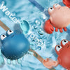 Niedliche mechanische Fischbadspielzeuge in blau und pink schwimmen im Wasser.