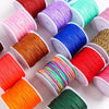 A collection of colorful macrame cord rolls in various shades including pink, orange, blue, green, and red.