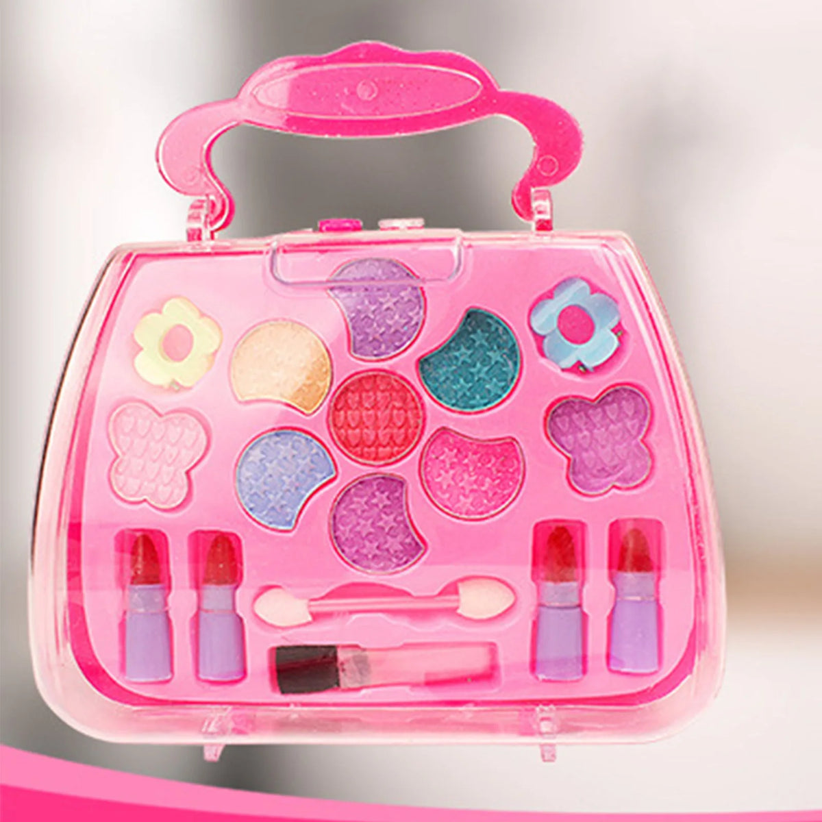 A pink plastic cosmetic case for pretend play makeup with various colored makeup items and brushes.