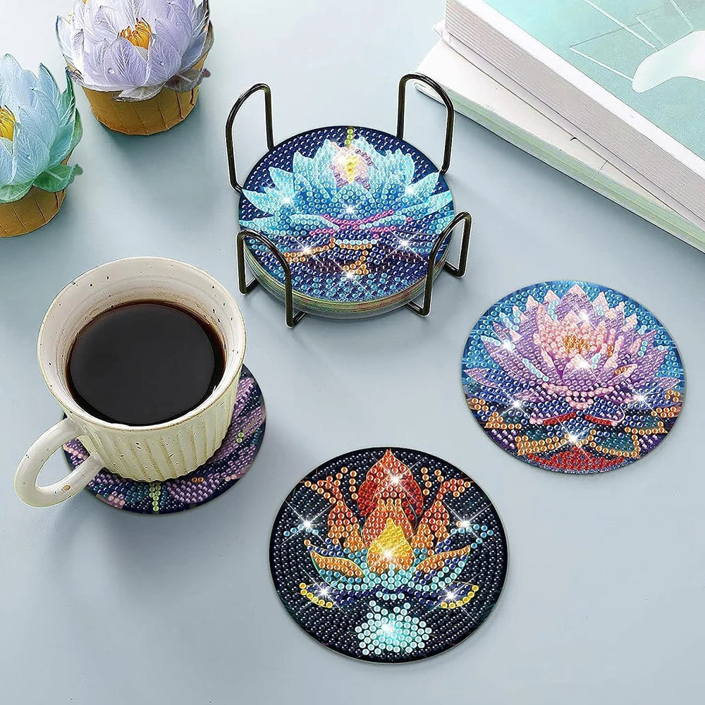 A set of diamond art coasters featuring floral designs and a metal holder are displayed on a light gray surface.