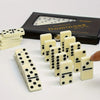 A set of double six dominoes with 28 tiles is displayed next to its black box.