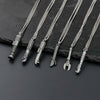 Five silver metal saber keychain necklaces hanging on a dark surface.
