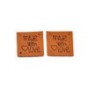 Two brown embossed leather labels with the text Made with Love engraved on them