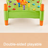 A green toy hammer with orange handles and various colored pegs for a toddler fine motor game.