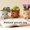 A set of adorable potted succulent plush toys with green leaves and orange soil resting on an open book.