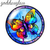 A round glass cabochon featuring a vibrant, iridescent butterfly design in shades of yellow, orange, and blue.