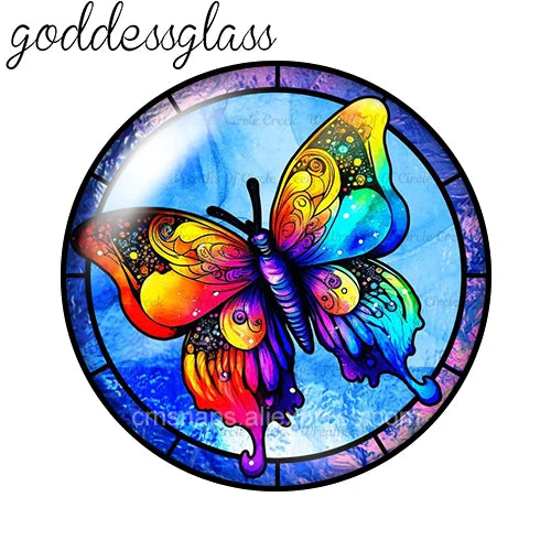 A round glass cabochon featuring a vibrant, iridescent butterfly design in shades of yellow, orange, and blue.